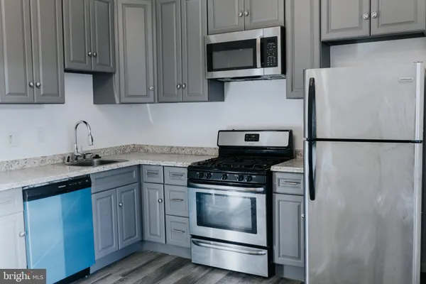 a kitchen with appliances a sink and cabinets