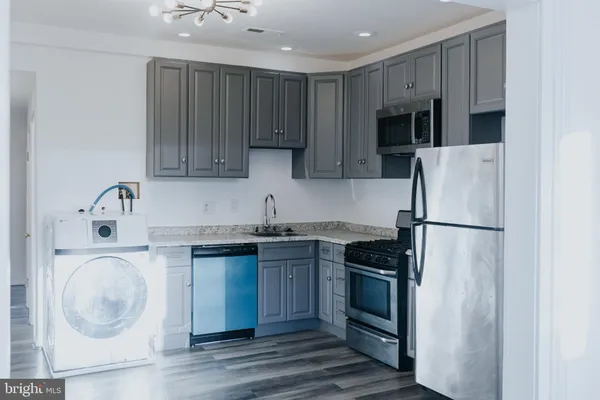a kitchen with a sink a refrigerator and cabinets