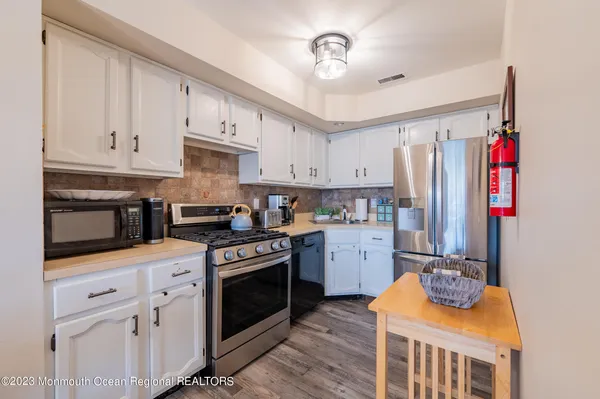 a kitchen with stainless steel appliances granite countertop a stove refrigerator and cabinets