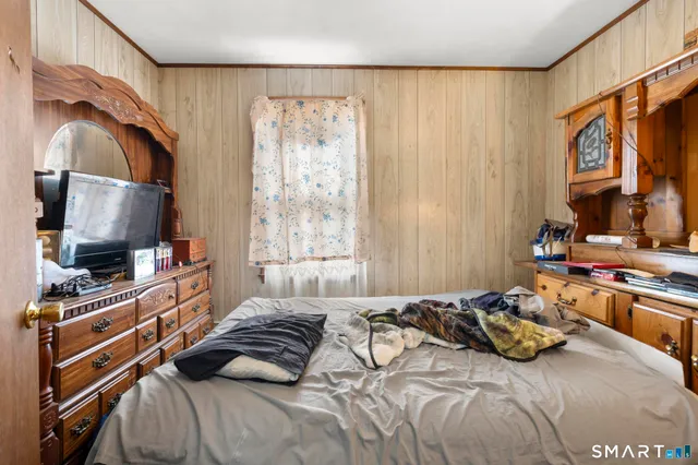 a bedroom with a bed and a flat tv screen