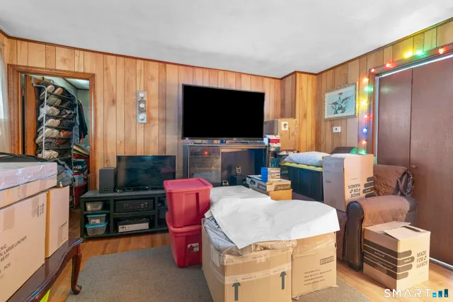a living room with furniture a flat screen tv and a floor to ceiling window