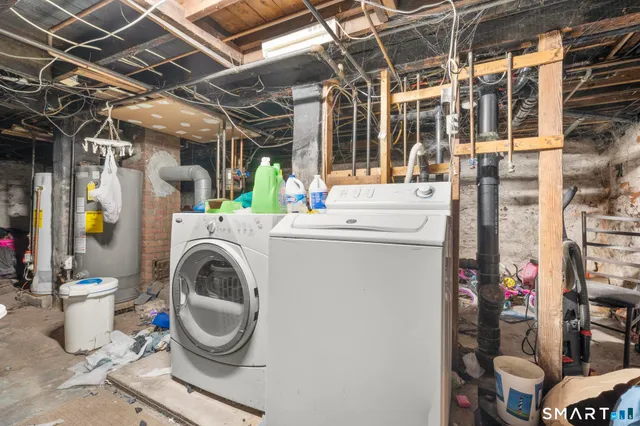 a utility room with dryer washer and a view of living room