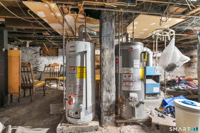 a view of a storage room with water heater and chairs