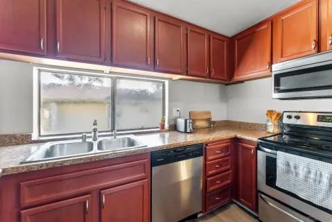 a kitchen with stainless steel appliances granite countertop a stove microwave and cabinets