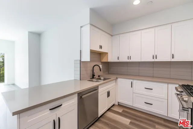 a kitchen with white cabinets appliances and a sink