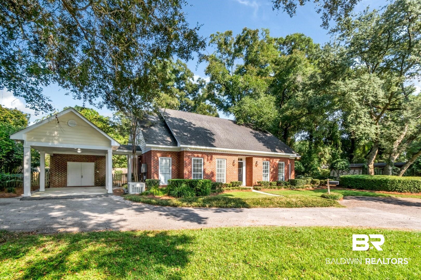 105 McHugh Lane Mobile, AL 36608 - Photo 30 of 30 View of front facade featuring driveway, a front lawn, brick siding, a shingled roof, and an attached carport