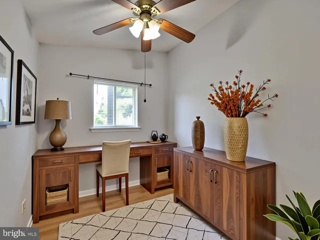 a view of a workspace with furniture and a window