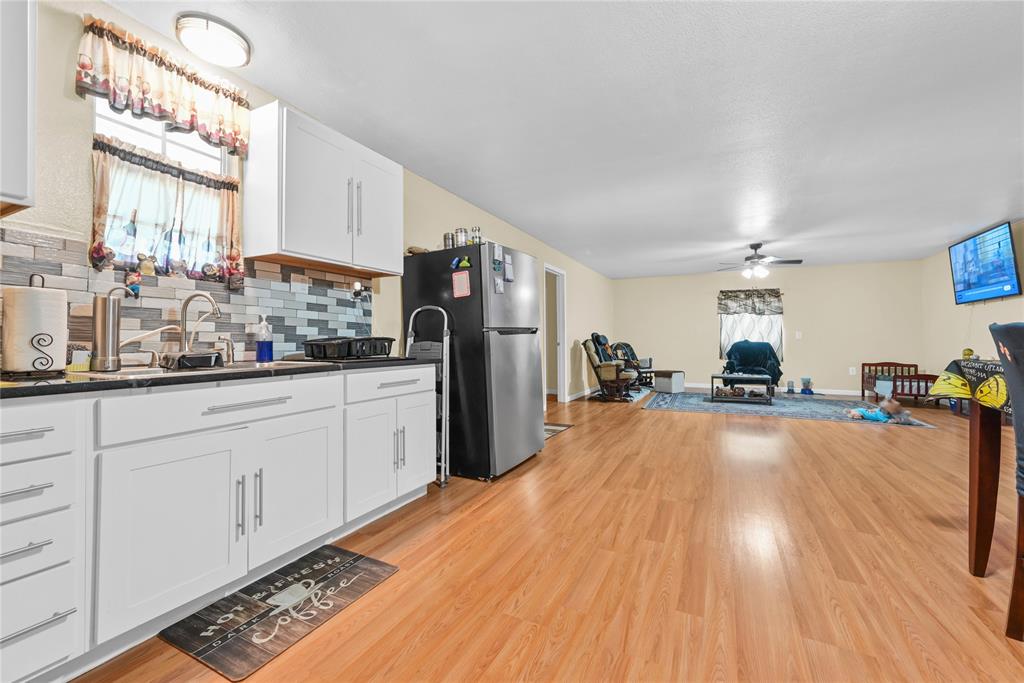 447 Masthead Road Gun Barrel City, TX 75156 - Photo 19 of 27 a large kitchen with stainless steel appliances a large window a oven and white cabinets with wooden floor