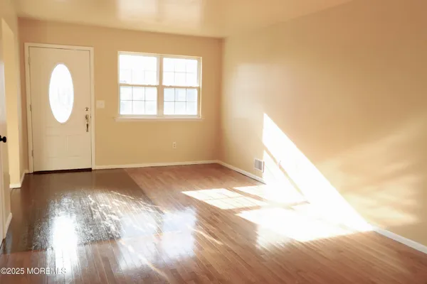 a view of a room with wooden floor and window