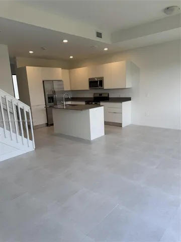 a view of kitchen with kitchen island stainless steel appliances counter top space