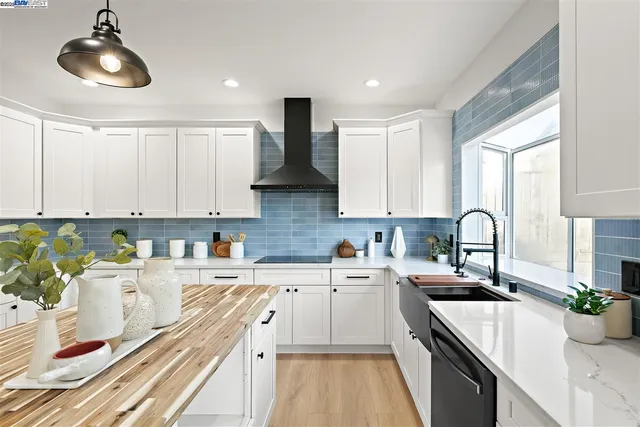 a kitchen with stainless steel appliances white cabinets and a refrigerator