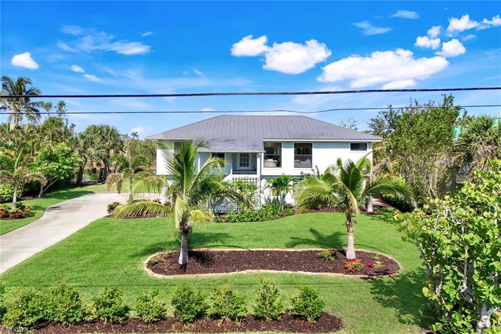 a front view of a house with a yard and potted plants