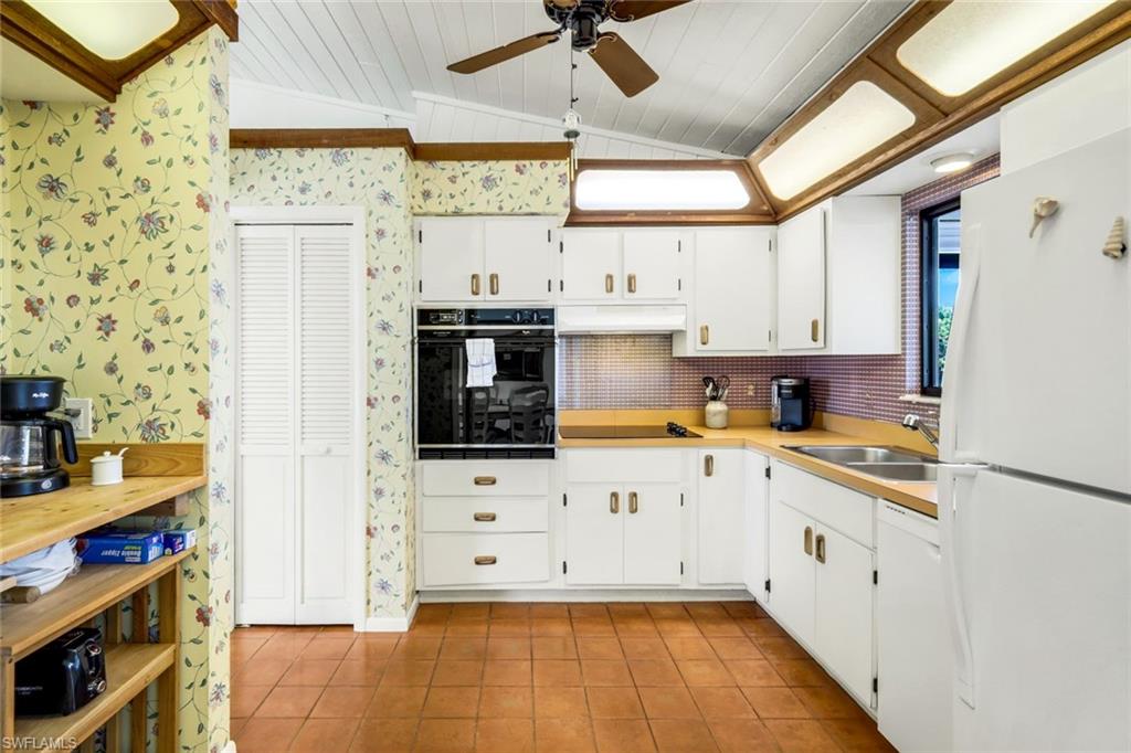 647 Rabbit Road Sanibel, FL 33957 - Photo 16 of 46 a kitchen with cabinets a window and appliances