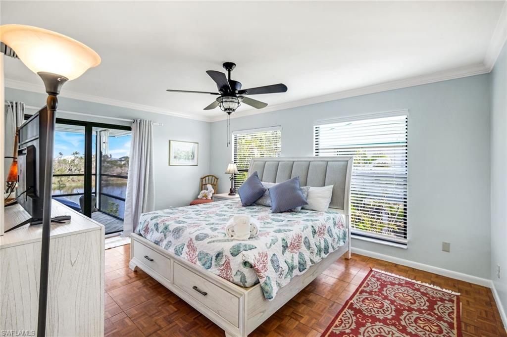 647 Rabbit Road Sanibel, FL 33957 - Photo 19 of 46 a bedroom with a bed a chandelier and a dresser