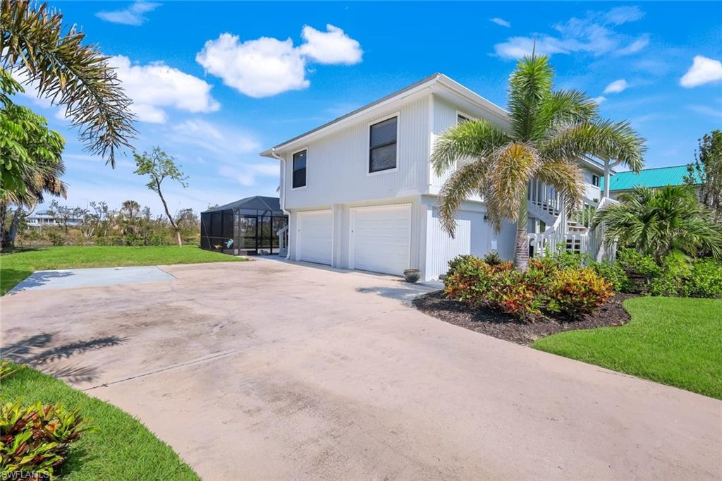 647 Rabbit Road Sanibel, FL 33957 - Photo 37 of 46 a view of a house with a yard and a garage