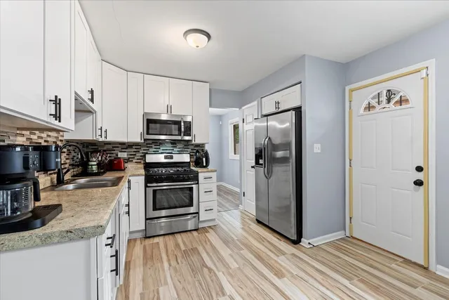 a kitchen with stainless steel appliances granite countertop a refrigerator and a stove top oven