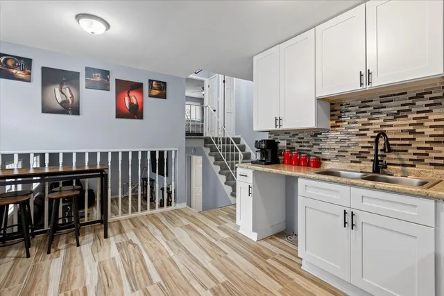 a kitchen with a refrigerator and white cabinets