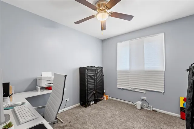 a view of room with workspace and a ceiling fan
