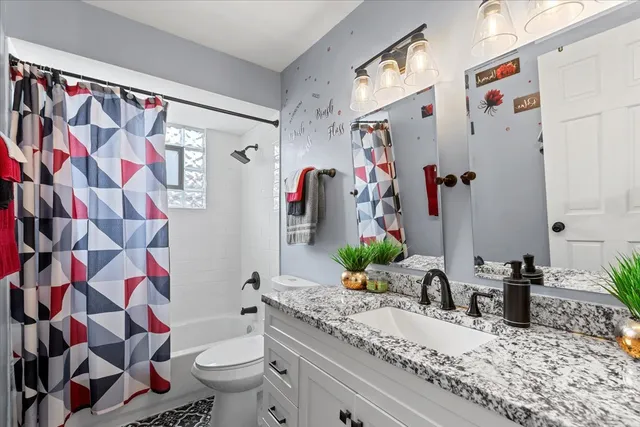 a bathroom with a sink a toilet and shower curtain