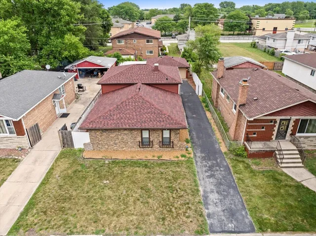 an aerial view of a house with a garden and lake view