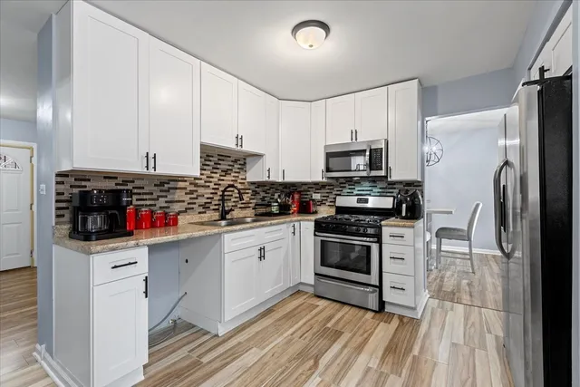 a kitchen with stainless steel appliances a stove sink microwave and cabinets