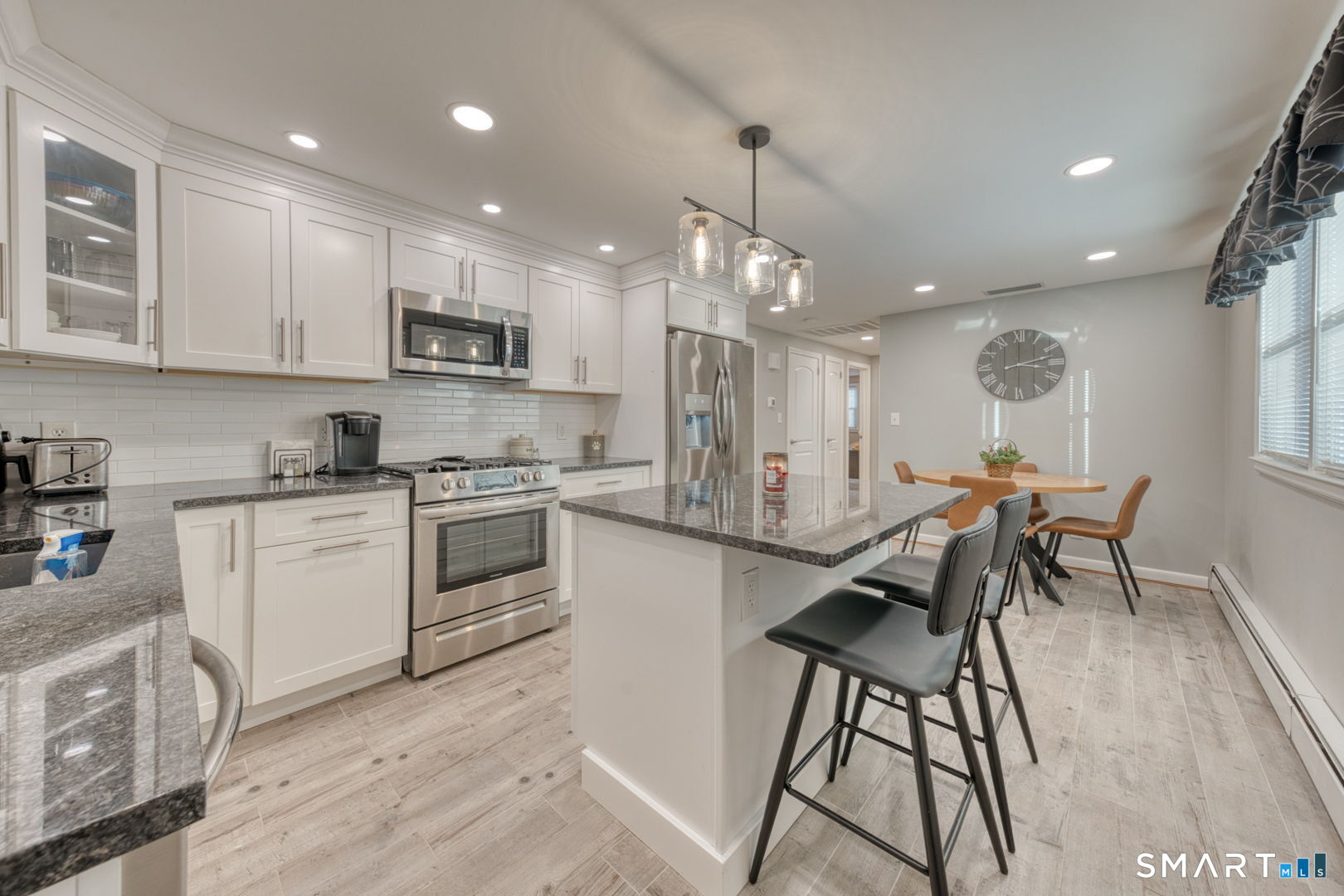 42 Northbrick Lane Wethersfield, CT 06109 - Photo 16 of 37 a kitchen with stainless steel appliances kitchen island granite countertop a stove a sink a refrigerator and white cabinets with wooden floor