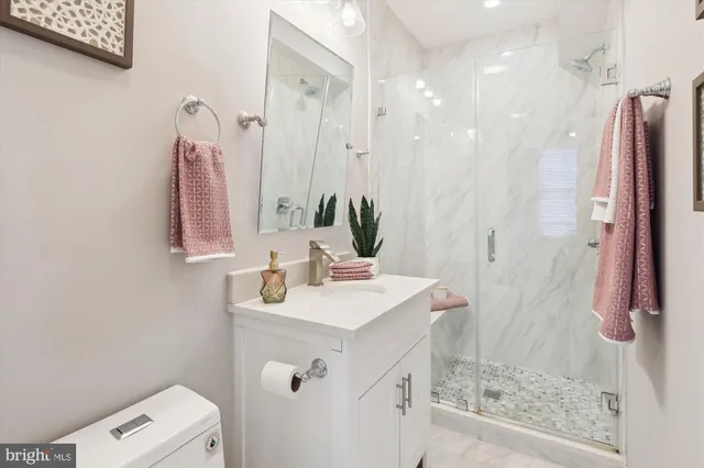a bathroom with a sink vanity mirror and shower
