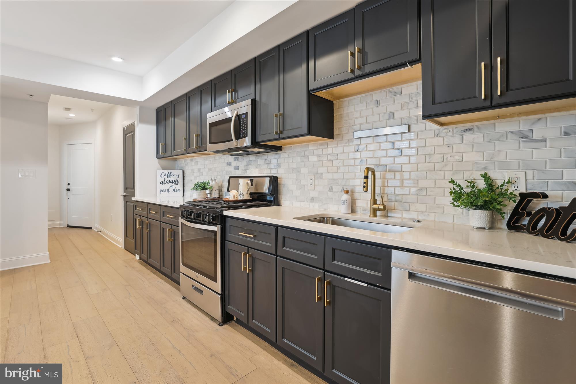 200 Hamilton Street Northwest, Unit 2 Washington, DC 20011 - Photo 2 of 16 a kitchen with stainless steel appliances granite countertop a sink a stove a refrigerator cabinets and a counter top space