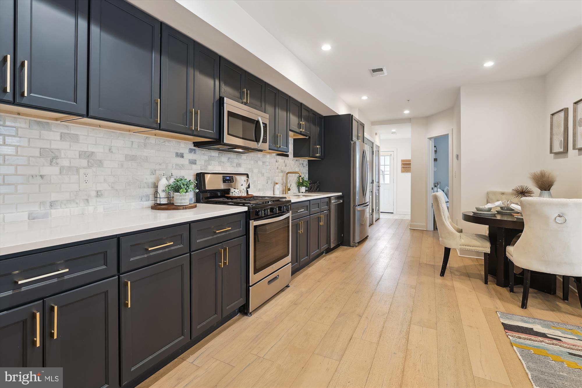200 Hamilton Street Northwest, Unit 2 Washington, DC 20011 - Photo 3 of 16 a kitchen with stainless steel appliances granite countertop wooden cabinets a sink dishwasher a stove and a refrigerator with wooden floor
