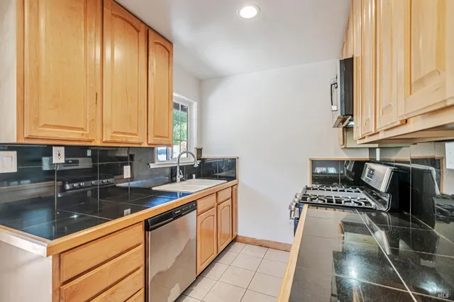 a kitchen with stainless steel appliances granite countertop a sink stove and cabinets