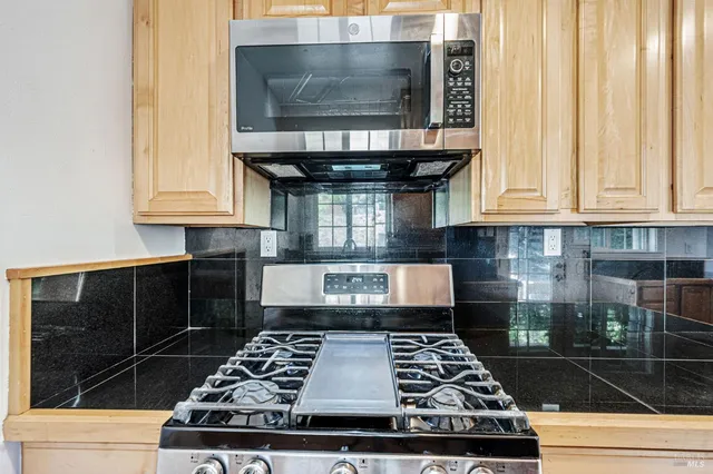 a kitchen with stainless steel appliances granite countertop a refrigerator and a stove
