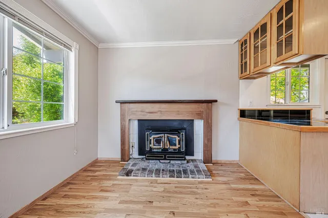 an empty room with wooden floor and fireplace