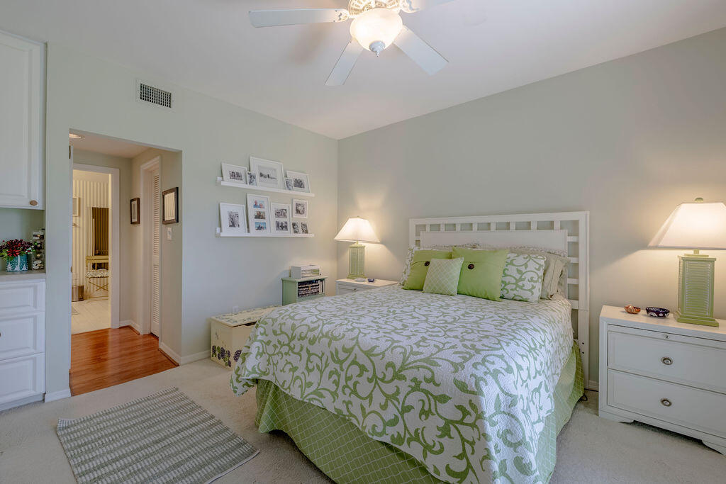 5520 East Harbor Village Drive, Unit 101 Vero Beach, FL 32967 - Photo 18 of 54 a bedroom with a bed and a chandelier