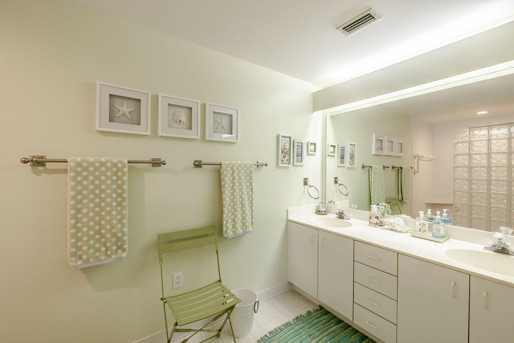 5520 East Harbor Village Drive, Unit 101 Vero Beach, FL 32967 - Photo 28 of 54 a bathroom with a double vanity sink mirror and shower