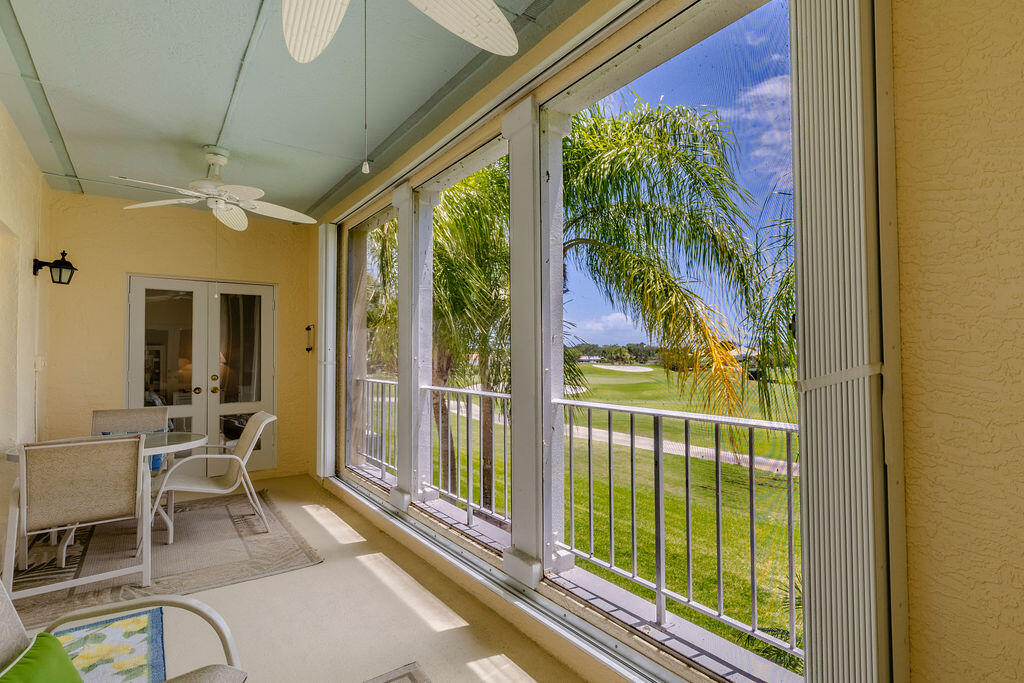 5520 East Harbor Village Drive, Unit 101 Vero Beach, FL 32967 - Photo 36 of 54 a view of a porch with chairs and floor to ceiling window