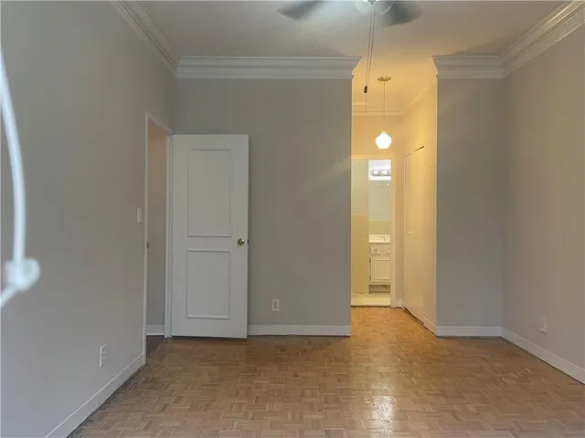 a view of an empty room with closet and wooden floor