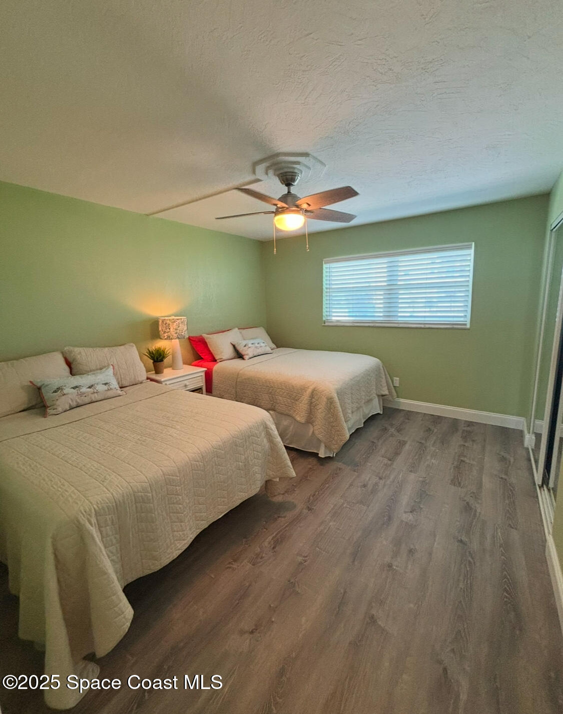 171 North Atlantic Avenue, Unit 39 Cocoa Beach, FL 32931 - Photo 14 of 29 a bedroom with two beds and a ceiling fan