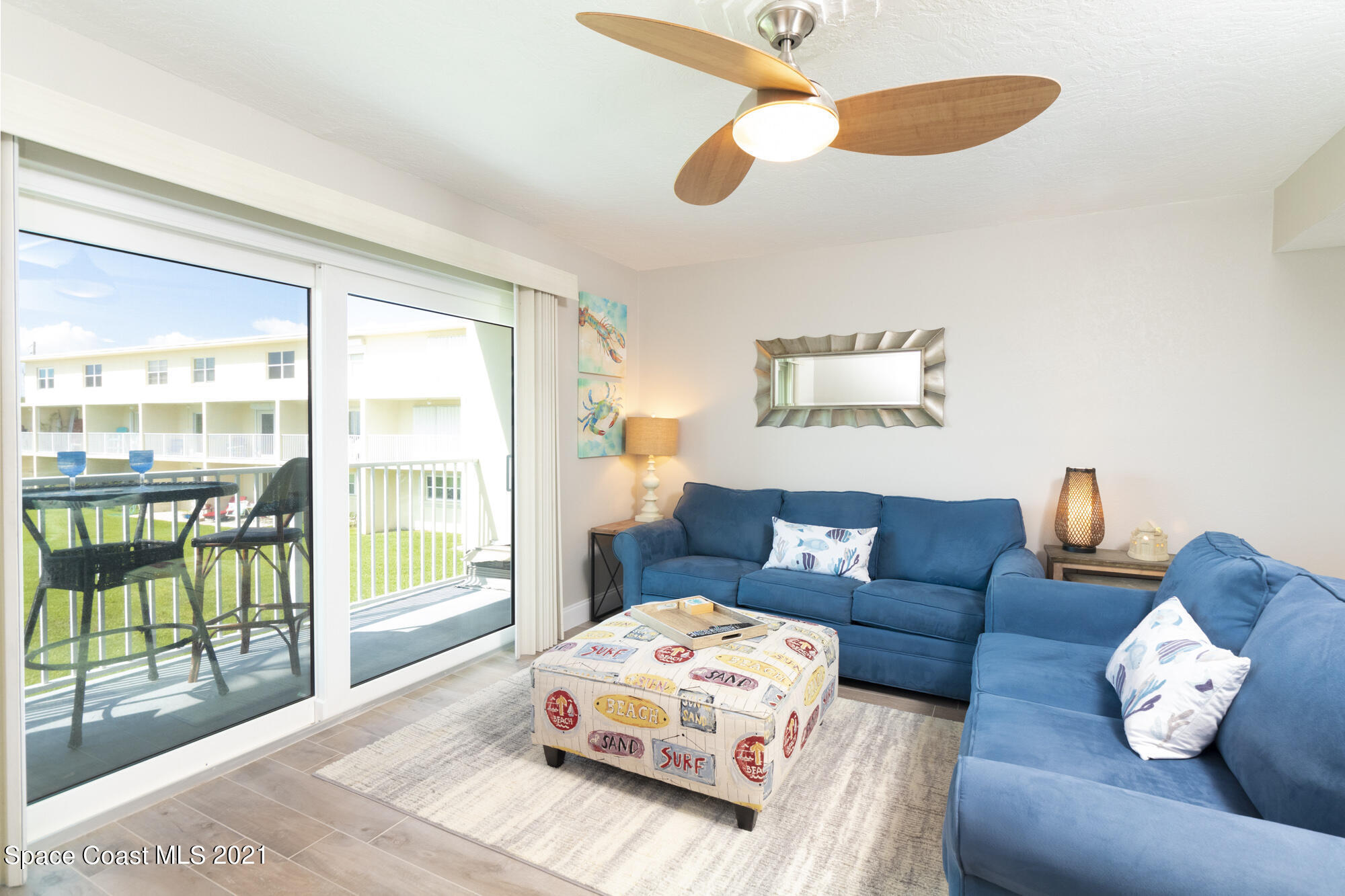 171 North Atlantic Avenue, Unit 39 Cocoa Beach, FL 32931 - Photo 6 of 29 a living room with furniture and a large window