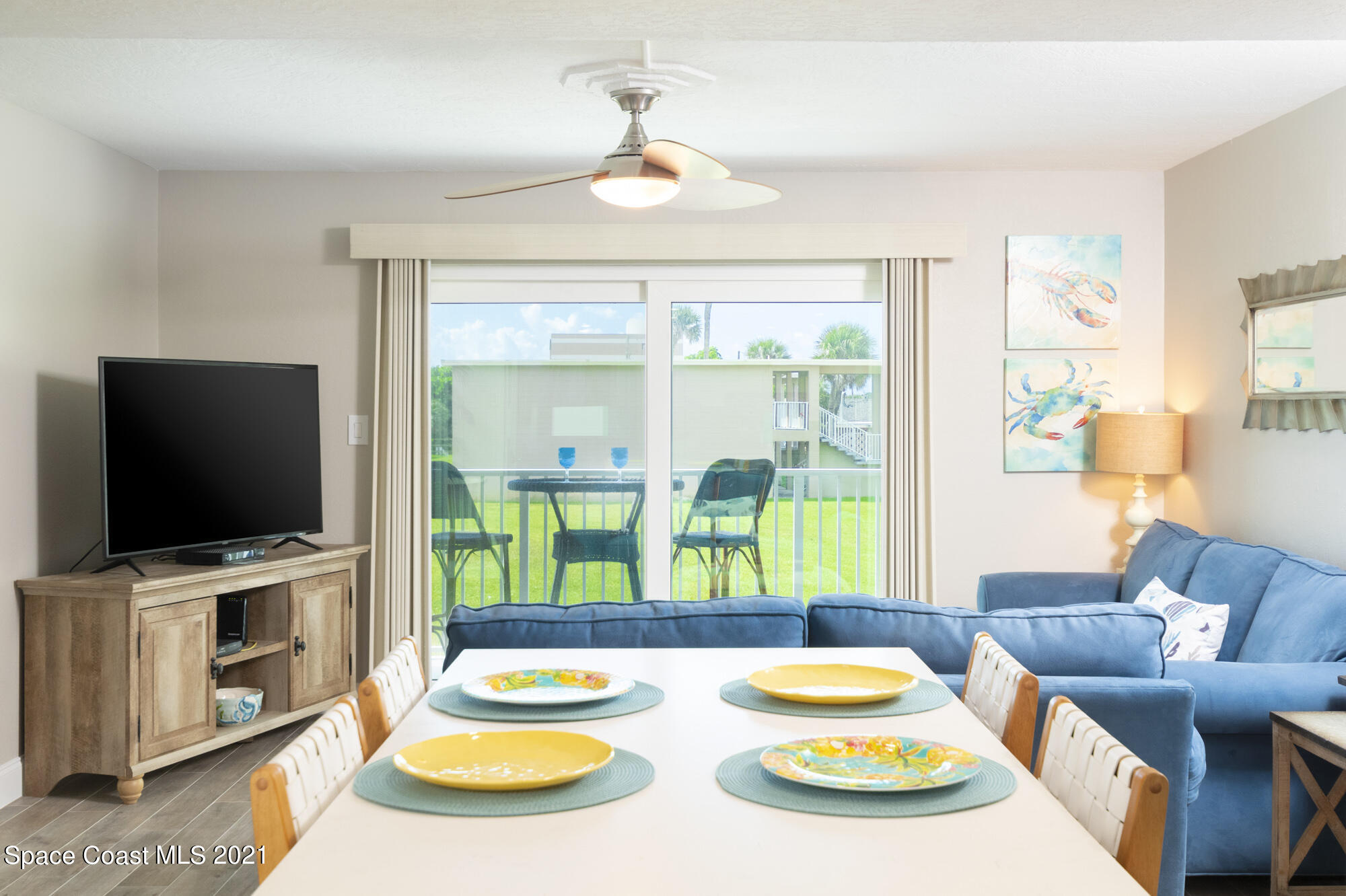 171 North Atlantic Avenue, Unit 39 Cocoa Beach, FL 32931 - Photo 7 of 29 a dining room with furniture and a flat screen tv