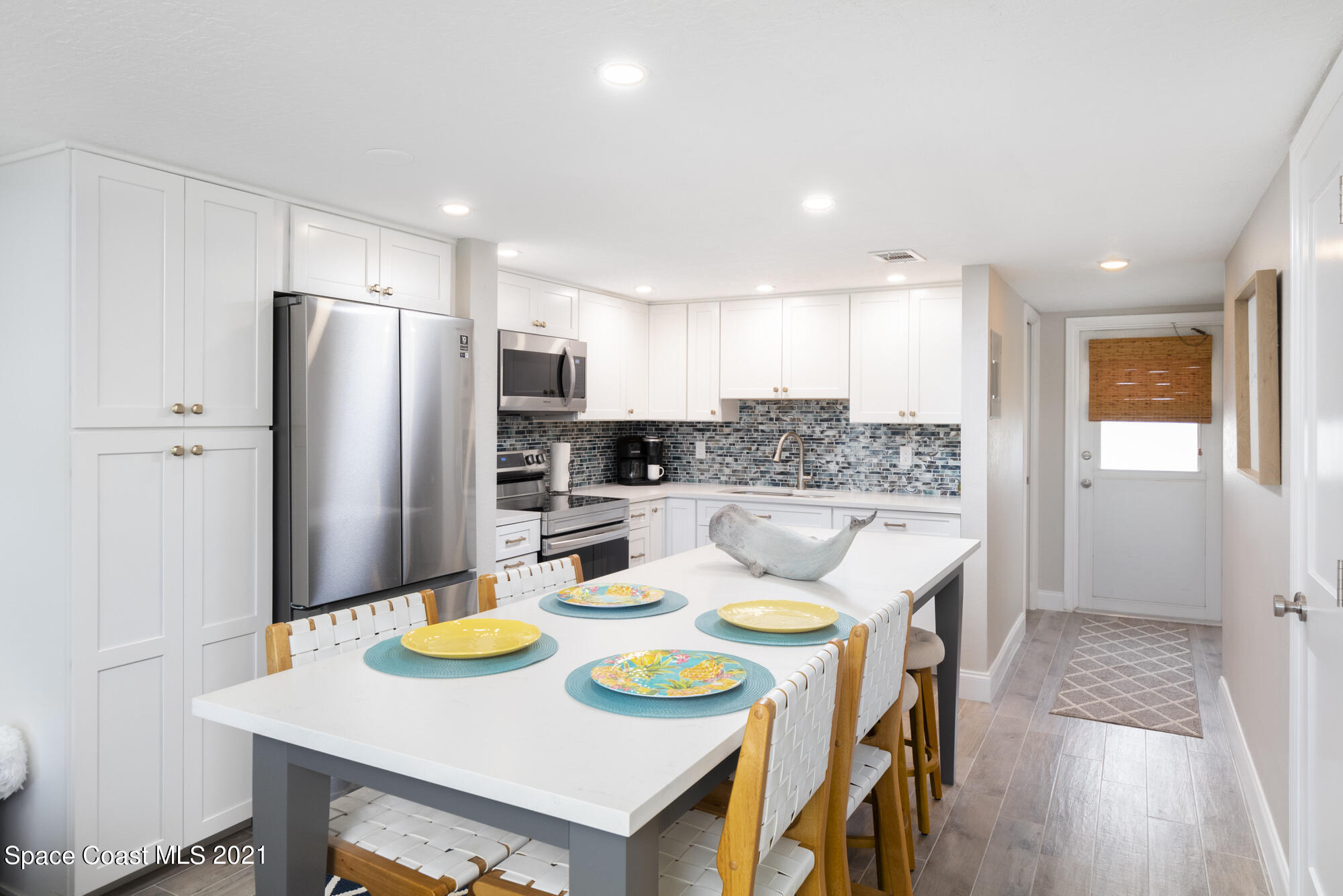 171 North Atlantic Avenue, Unit 39 Cocoa Beach, FL 32931 - Photo 9 of 29 a kitchen that has a dining table and chairs