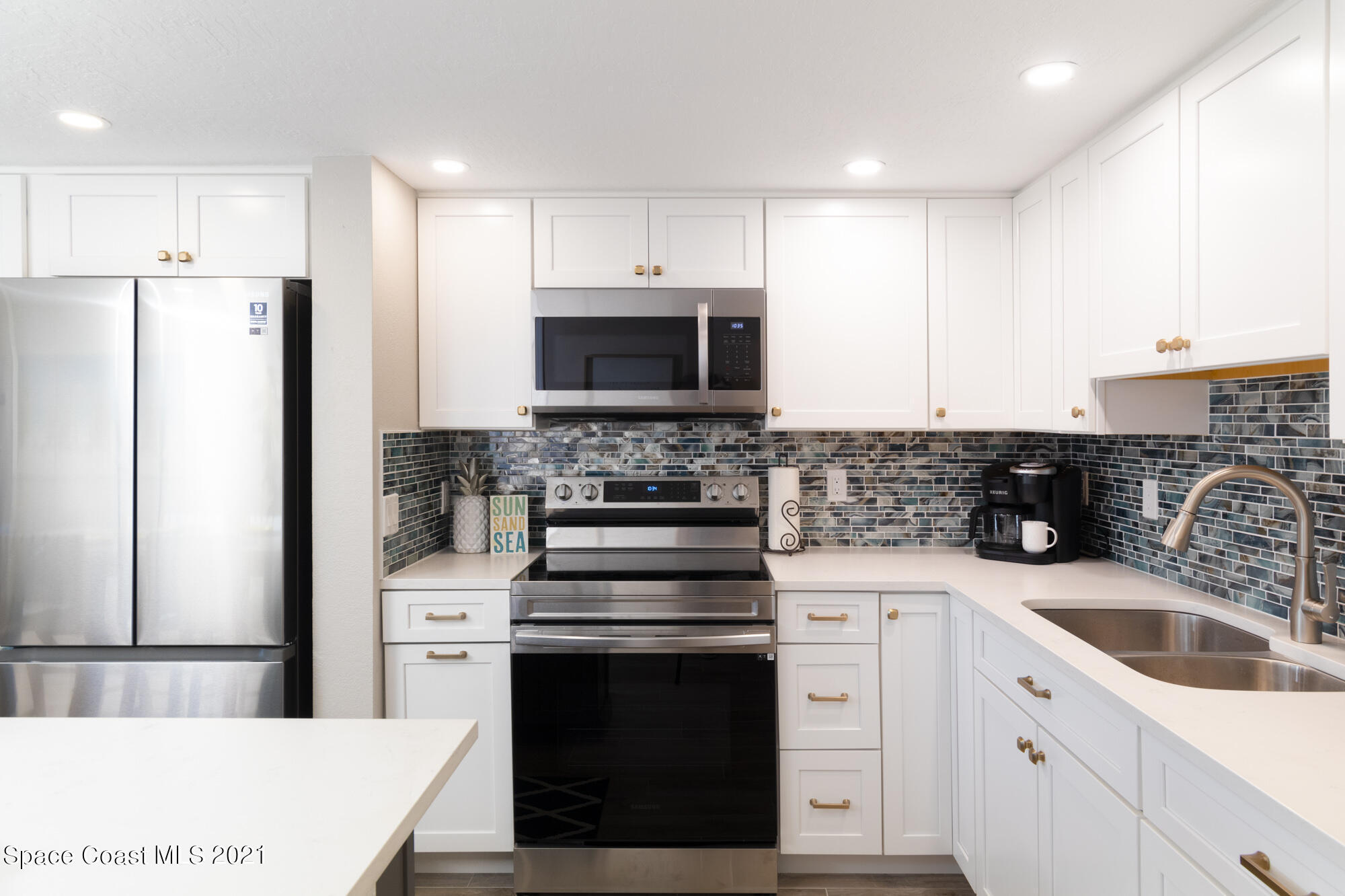 171 North Atlantic Avenue, Unit 39 Cocoa Beach, FL 32931 - Photo 10 of 29 a kitchen with a sink stove and refrigerator