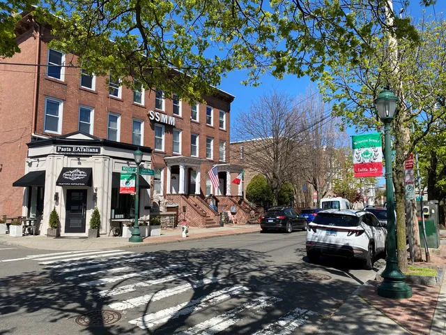 a front view of a building with lots of cars parked on road