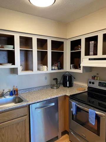 a kitchen with stainless steel appliances granite countertop a sink stove and cabinets
