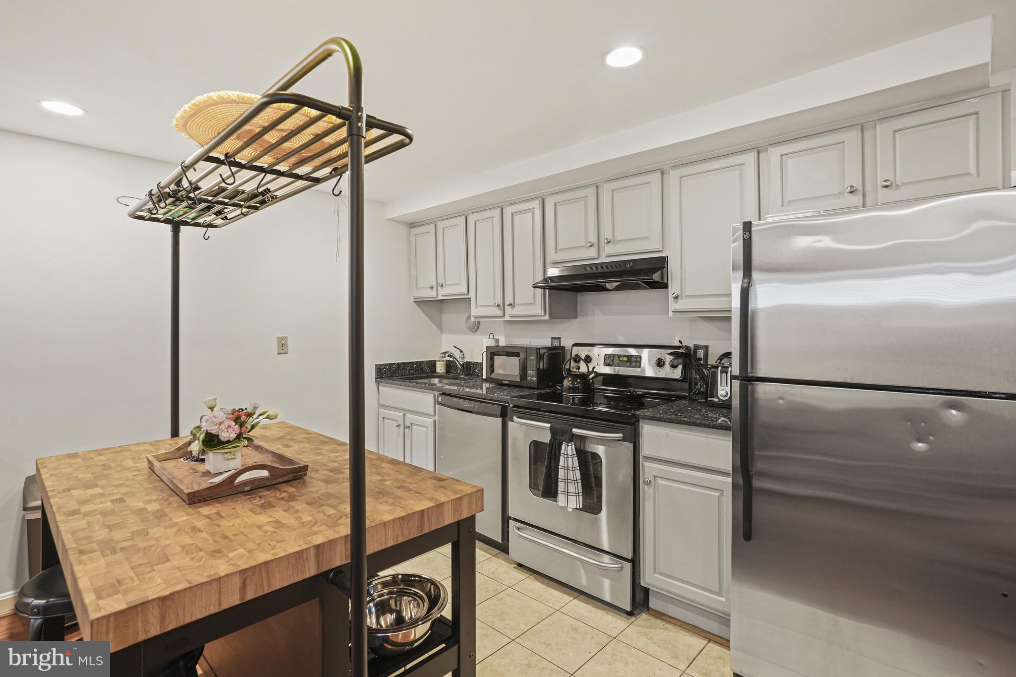 1321 Fairmont Street Northwest, Unit 1 Washington, DC 20009 - Photo 12 of 22 a kitchen with stainless steel appliances granite countertop a sink a stove and refrigerator