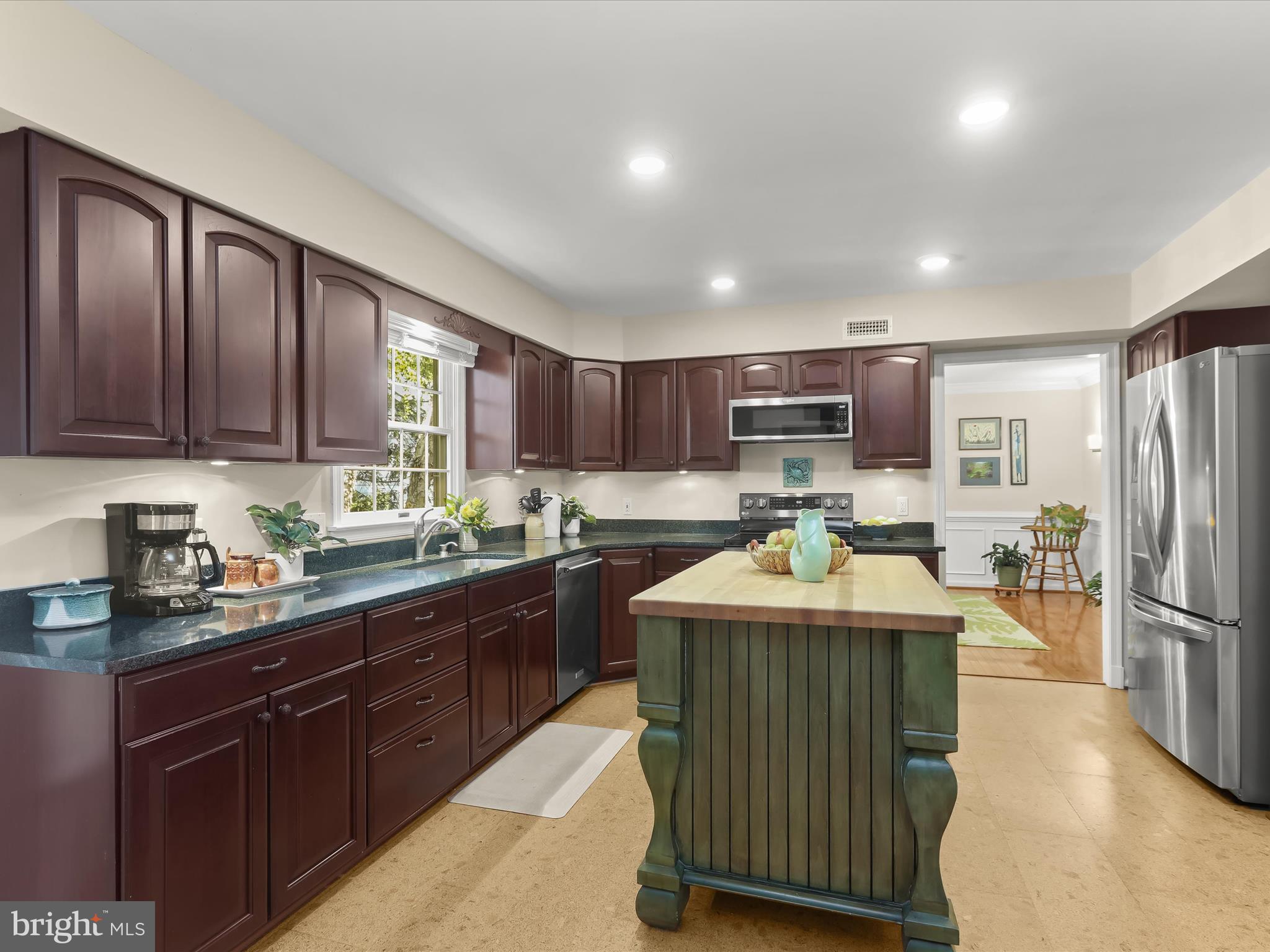 10634 Quarterstaff Road Columbia, MD 21044 - Photo 22 of 62 a kitchen with kitchen island granite countertop stainless steel appliances a sink a stove a refrigerator cabinets and a dining table