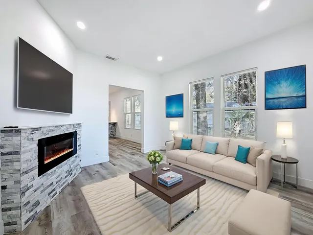 a living room with furniture a fireplace and a flat screen tv