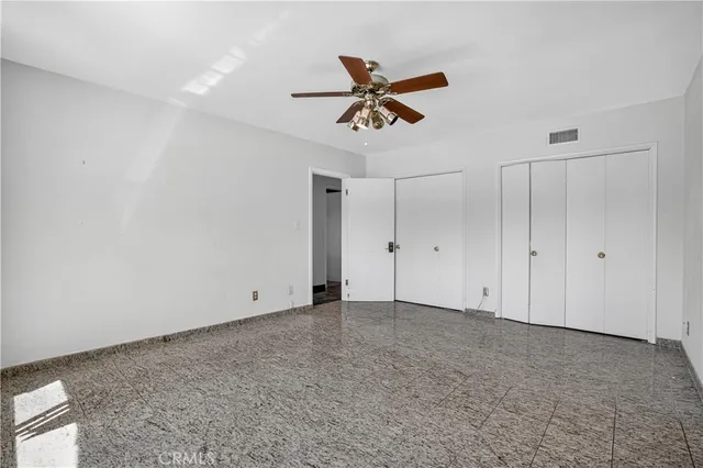 a view of an empty room with a window and a ceiling fan