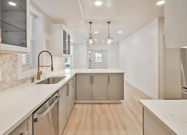 a kitchen with a sink a counter space appliances and cabinets
