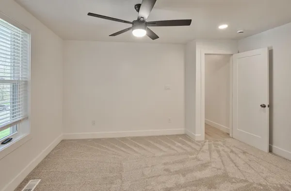 an empty room with fan and windows