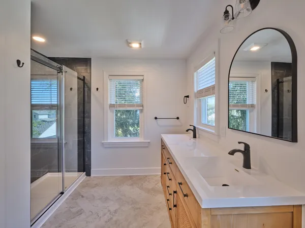 a bathroom with a tub a sink and mirror